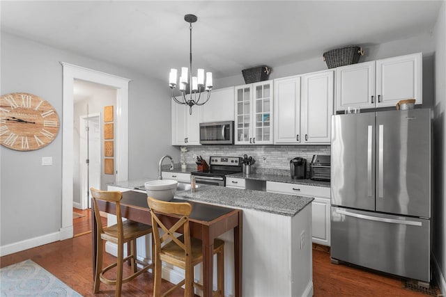 kitchen featuring dark hardwood / wood-style floors, an island with sink, sink, white cabinets, and stainless steel appliances