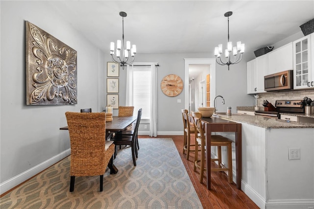 dining space featuring dark hardwood / wood-style floors, a chandelier, and sink