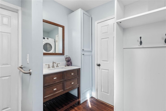 bathroom featuring hardwood / wood-style flooring, vanity, and washer / dryer