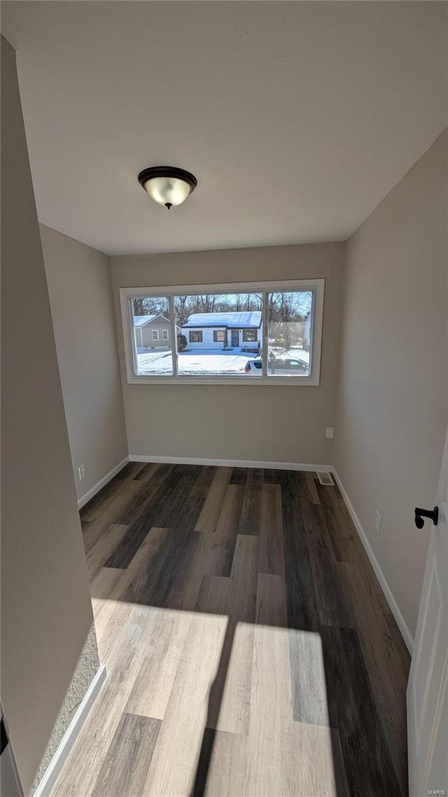 spare room with a healthy amount of sunlight and dark hardwood / wood-style flooring