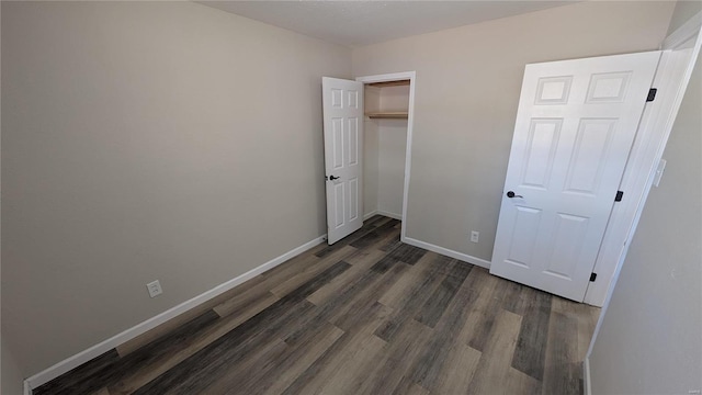 unfurnished bedroom featuring dark hardwood / wood-style flooring and a closet