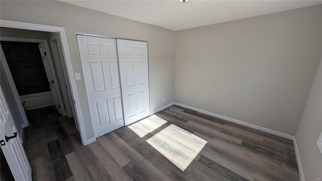 unfurnished bedroom featuring dark hardwood / wood-style flooring and a closet