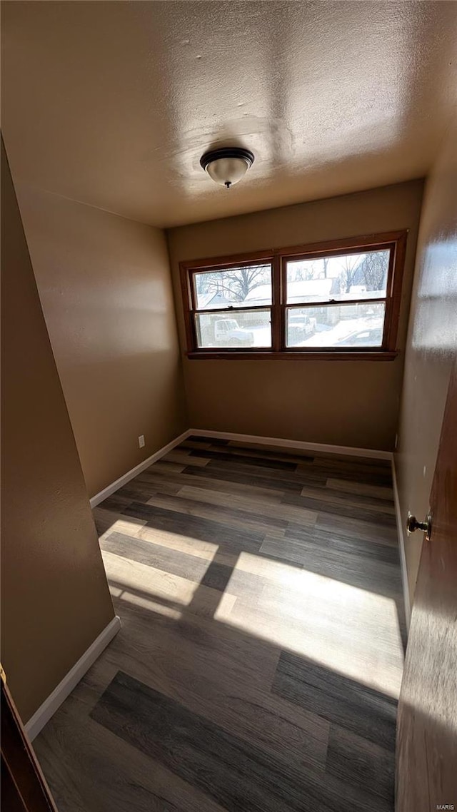 spare room with dark hardwood / wood-style flooring and a textured ceiling