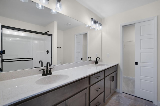 bathroom featuring vanity, a shower with door, and toilet