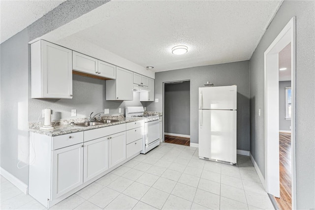 kitchen with sink, a textured ceiling, white cabinets, and white appliances