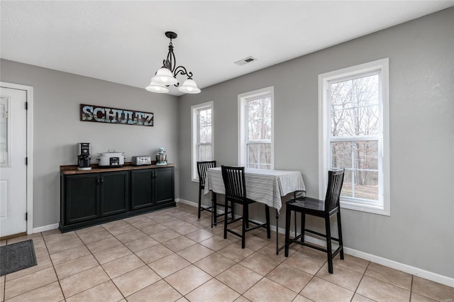 dining area with light tile patterned floors, a chandelier, and a healthy amount of sunlight