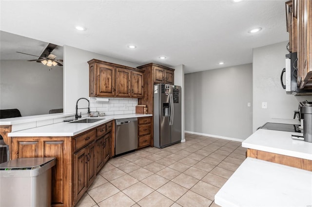 kitchen with tasteful backsplash, sink, ceiling fan, kitchen peninsula, and stainless steel appliances