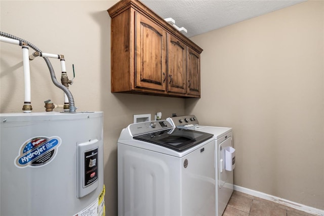 washroom with light tile patterned floors, cabinets, electric water heater, washer and dryer, and a textured ceiling