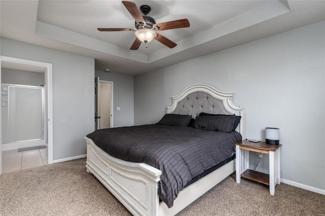 bedroom featuring light colored carpet, a raised ceiling, and ceiling fan