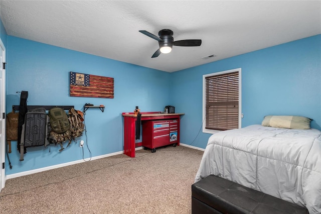 carpeted bedroom with ceiling fan and a textured ceiling