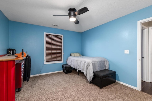 bedroom featuring ceiling fan, carpet, and a textured ceiling