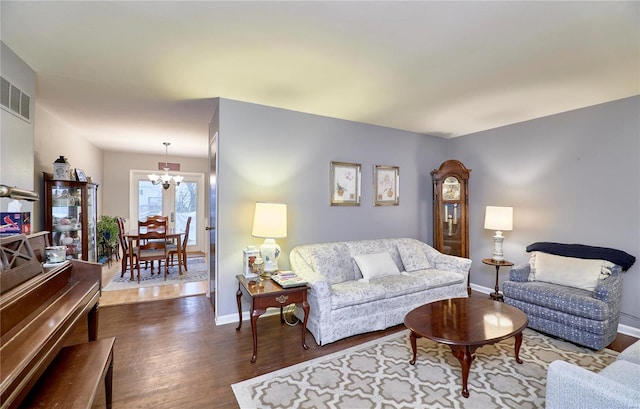 living room with a notable chandelier and dark hardwood / wood-style flooring