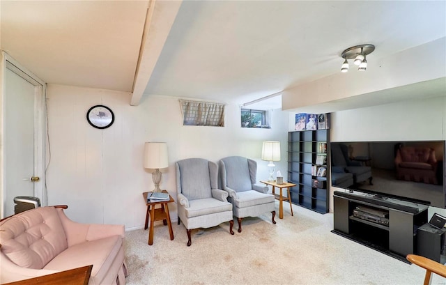 carpeted living room with beamed ceiling