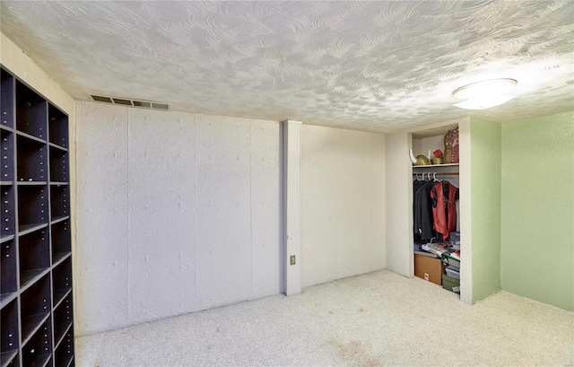 unfurnished bedroom featuring a closet, carpet floors, and a textured ceiling