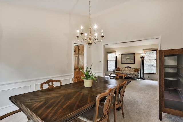 carpeted dining room featuring an inviting chandelier