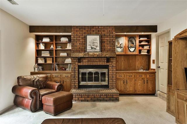 living room featuring light colored carpet, built in features, and a fireplace