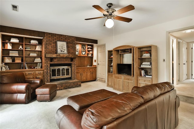 living room featuring ceiling fan, light carpet, built in features, and a fireplace