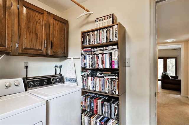 clothes washing area with cabinets, separate washer and dryer, and light carpet