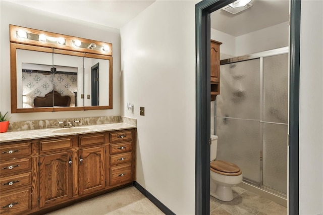 bathroom with vanity, a shower with door, and toilet