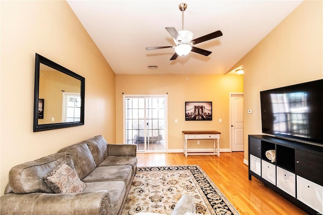 living room with ceiling fan, lofted ceiling, a wealth of natural light, and light hardwood / wood-style floors