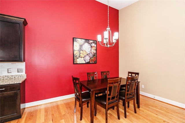 dining space featuring light wood-type flooring and a notable chandelier