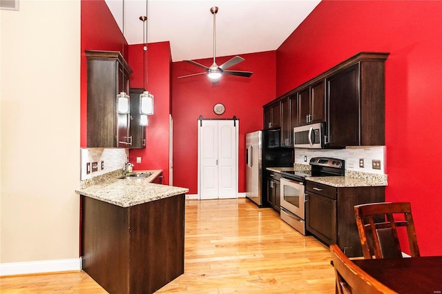 kitchen with sink, ceiling fan, stainless steel appliances, light hardwood / wood-style floors, and decorative backsplash