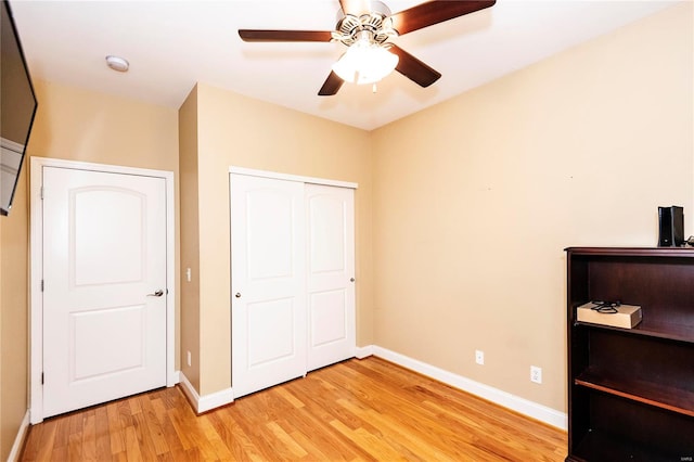 unfurnished bedroom with ceiling fan, a closet, and light hardwood / wood-style flooring