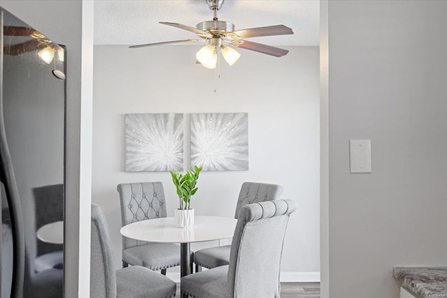 dining area with hardwood / wood-style flooring, ceiling fan, and a textured ceiling