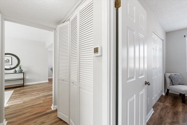 corridor featuring dark wood-type flooring and a textured ceiling