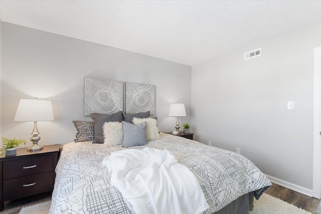 bedroom with hardwood / wood-style floors and a textured ceiling