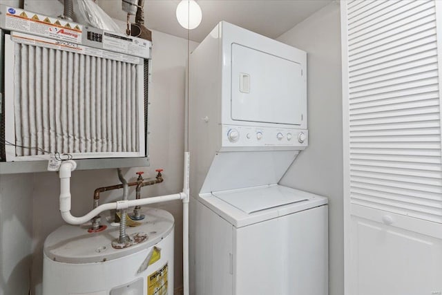 washroom featuring water heater and stacked washer and clothes dryer