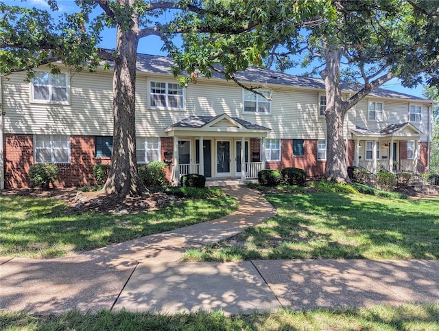 view of front of property featuring covered porch and a front lawn