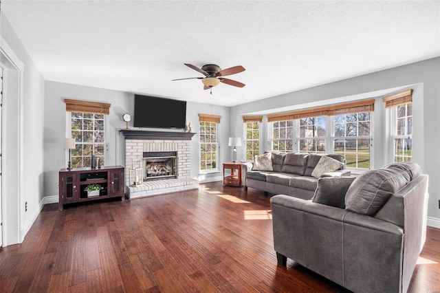 living room featuring dark hardwood / wood-style flooring, a fireplace, and a healthy amount of sunlight