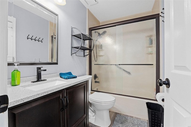 full bathroom featuring enclosed tub / shower combo, vanity, and toilet