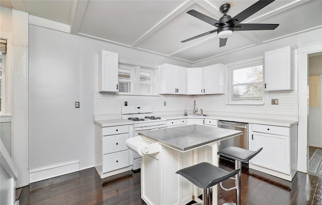 kitchen featuring sink, gas range gas stove, stainless steel dishwasher, a kitchen island, and white cabinets