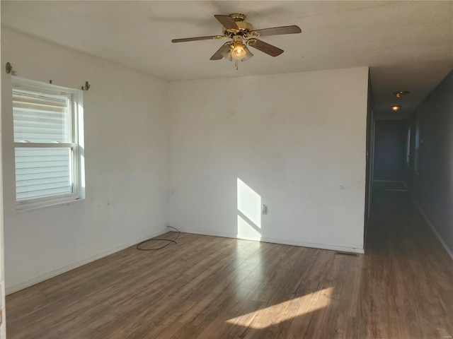 spare room featuring ceiling fan and dark hardwood / wood-style flooring