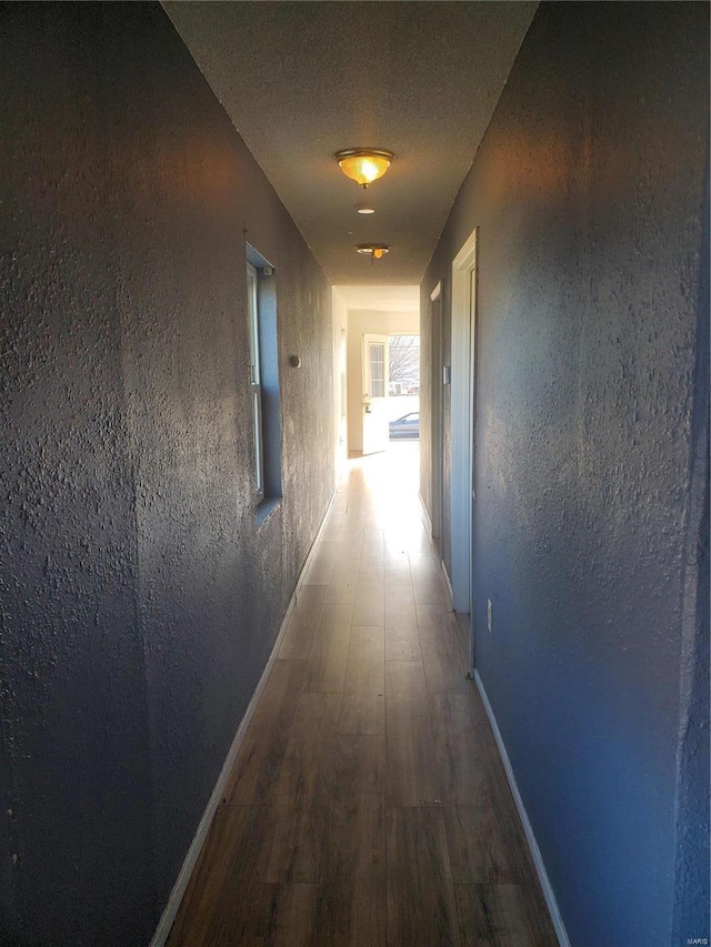 hallway with wood-type flooring and a textured ceiling