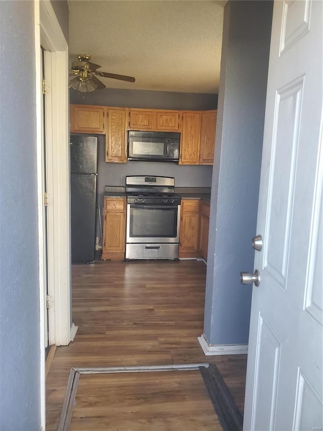 kitchen featuring dark hardwood / wood-style flooring, ceiling fan, black appliances, and a textured ceiling