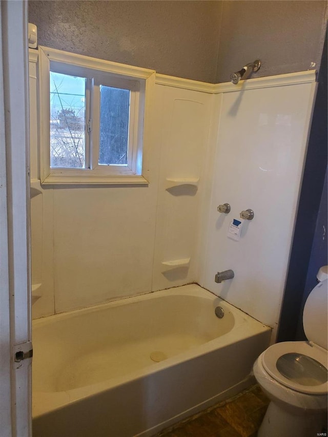 bathroom featuring toilet and shower / bathing tub combination