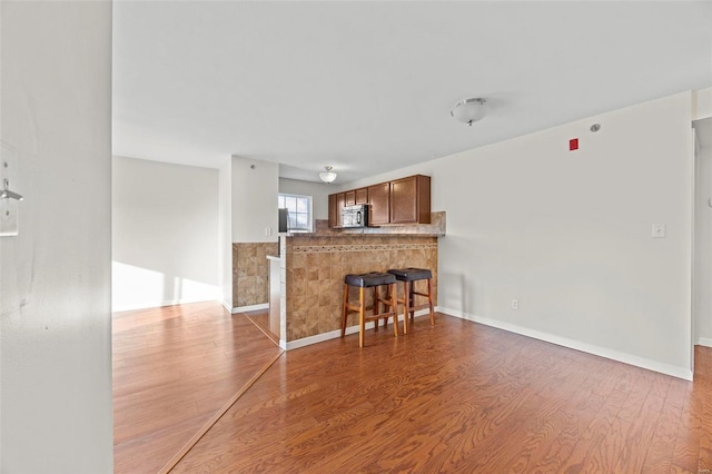 living area featuring baseboards and wood finished floors