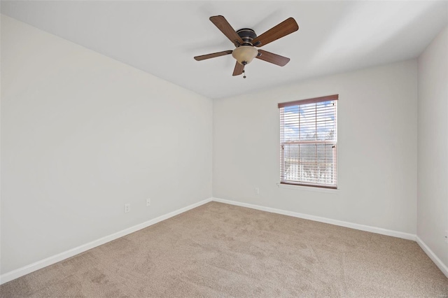 carpeted empty room with ceiling fan and baseboards