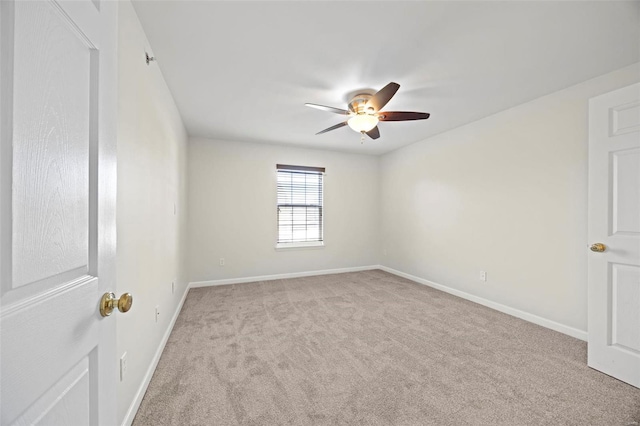 spare room featuring carpet, a ceiling fan, and baseboards