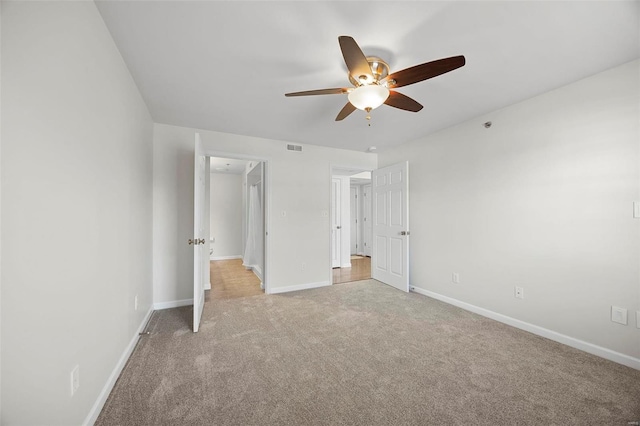 unfurnished bedroom featuring visible vents, baseboards, ceiling fan, and light colored carpet