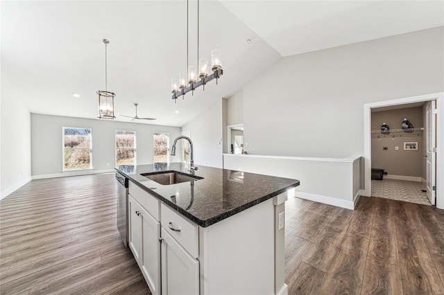 kitchen featuring dark wood-type flooring, open floor plan, vaulted ceiling, a sink, and dishwasher