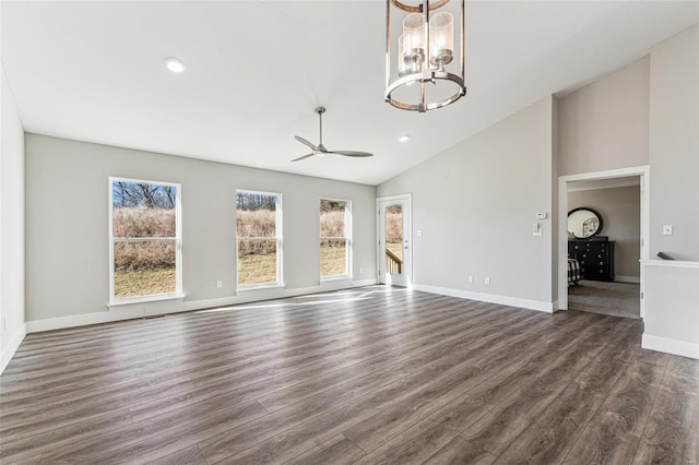 unfurnished living room with baseboards, dark wood-style flooring, ceiling fan with notable chandelier, high vaulted ceiling, and recessed lighting