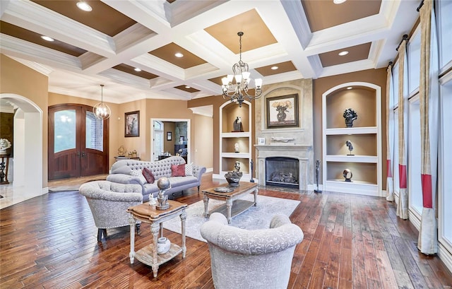 living room with beamed ceiling, dark hardwood / wood-style floors, and a chandelier