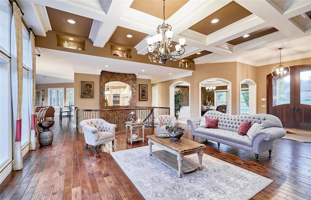 living room with dark hardwood / wood-style flooring, coffered ceiling, a notable chandelier, crown molding, and beam ceiling