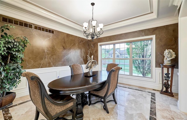 dining room featuring ornamental molding and a notable chandelier