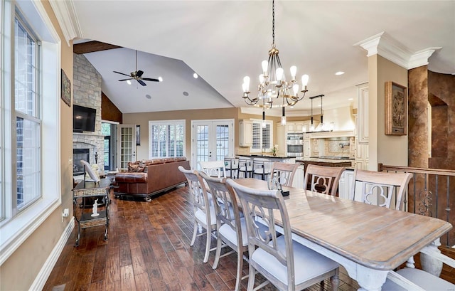 dining space with vaulted ceiling, a fireplace, ornamental molding, dark wood-type flooring, and french doors