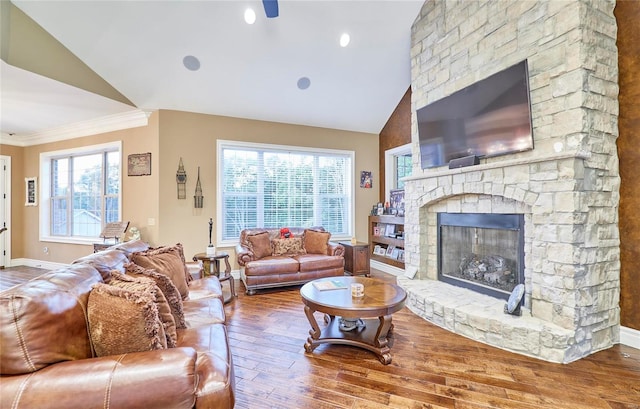 living room with crown molding, a fireplace, hardwood / wood-style floors, and vaulted ceiling